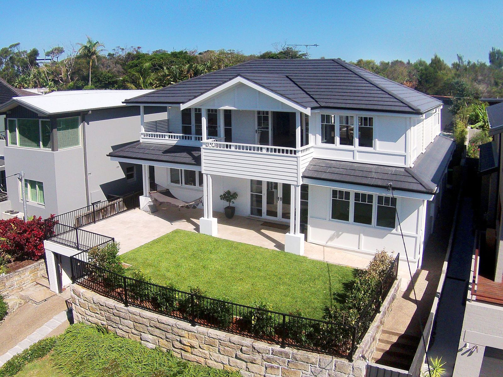 Balgowlah Heights — elevated view of a Hamptons-style two-storey home with lawn and sandstone wall, built by HP Constructions with All Australian Architecture