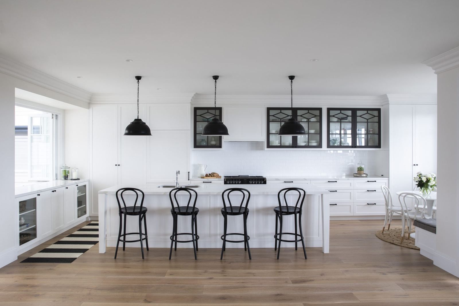 Balgowlah Heights — white kitchen island with black pendants, bentwood stools and timber floor, built by HP Constructions with All Australian Architecture