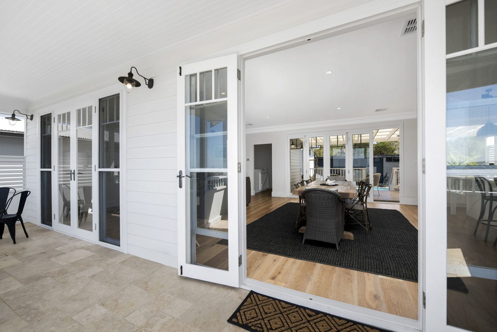 Balgowlah Heights — covered veranda with white doors and travertine floor to outdoor dining, built by HP Constructions with All Australian Architecture