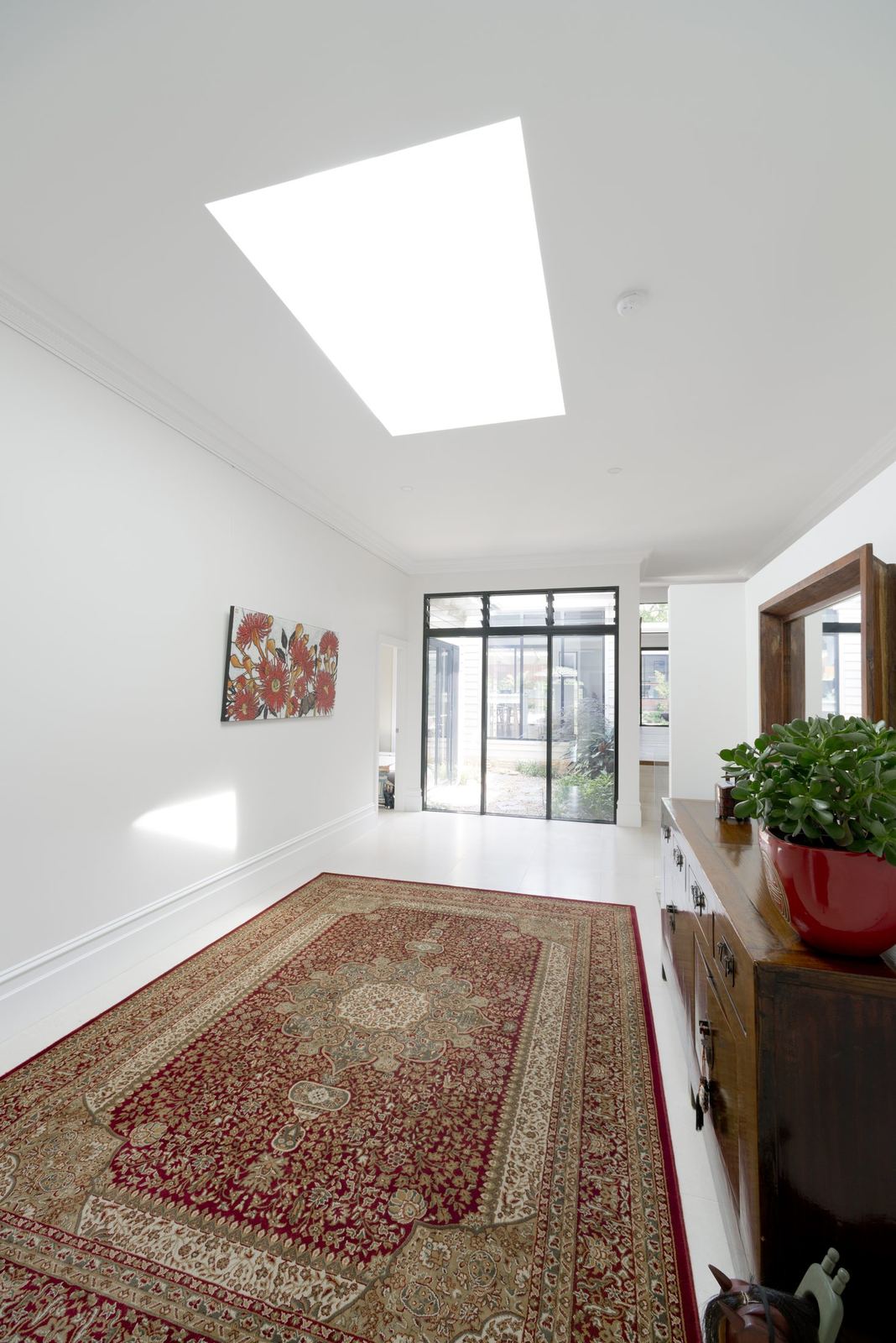 Balgowlah — living space with raked ceiling, skylight, timber floor and patterned rug, built by HP Constructions with Scope Architects