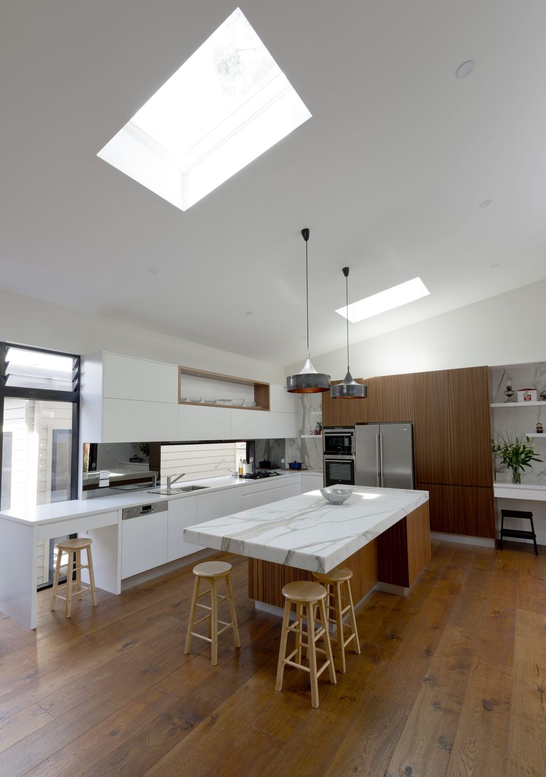 Balgowlah — white kitchen island with stone benchtop, bar stools and skylight above, built by HP Constructions with Scope Architects
