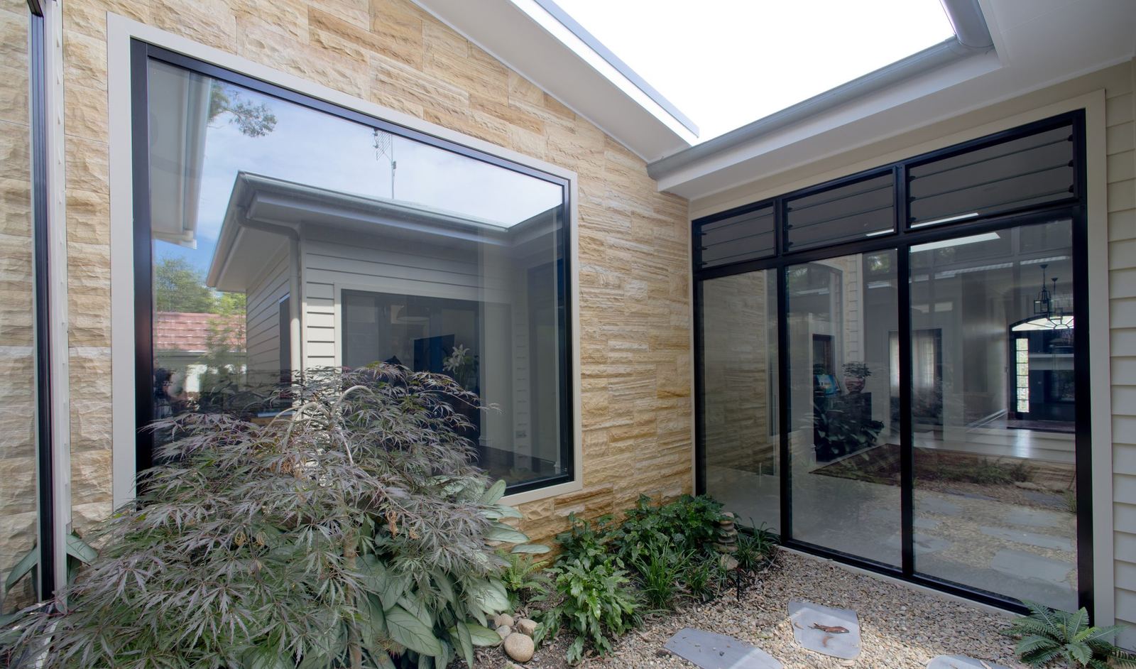 Balgowlah — sandstone-walled atrium courtyard with picture window, skylight and Japanese maple, built by HP Constructions with Scope Architects