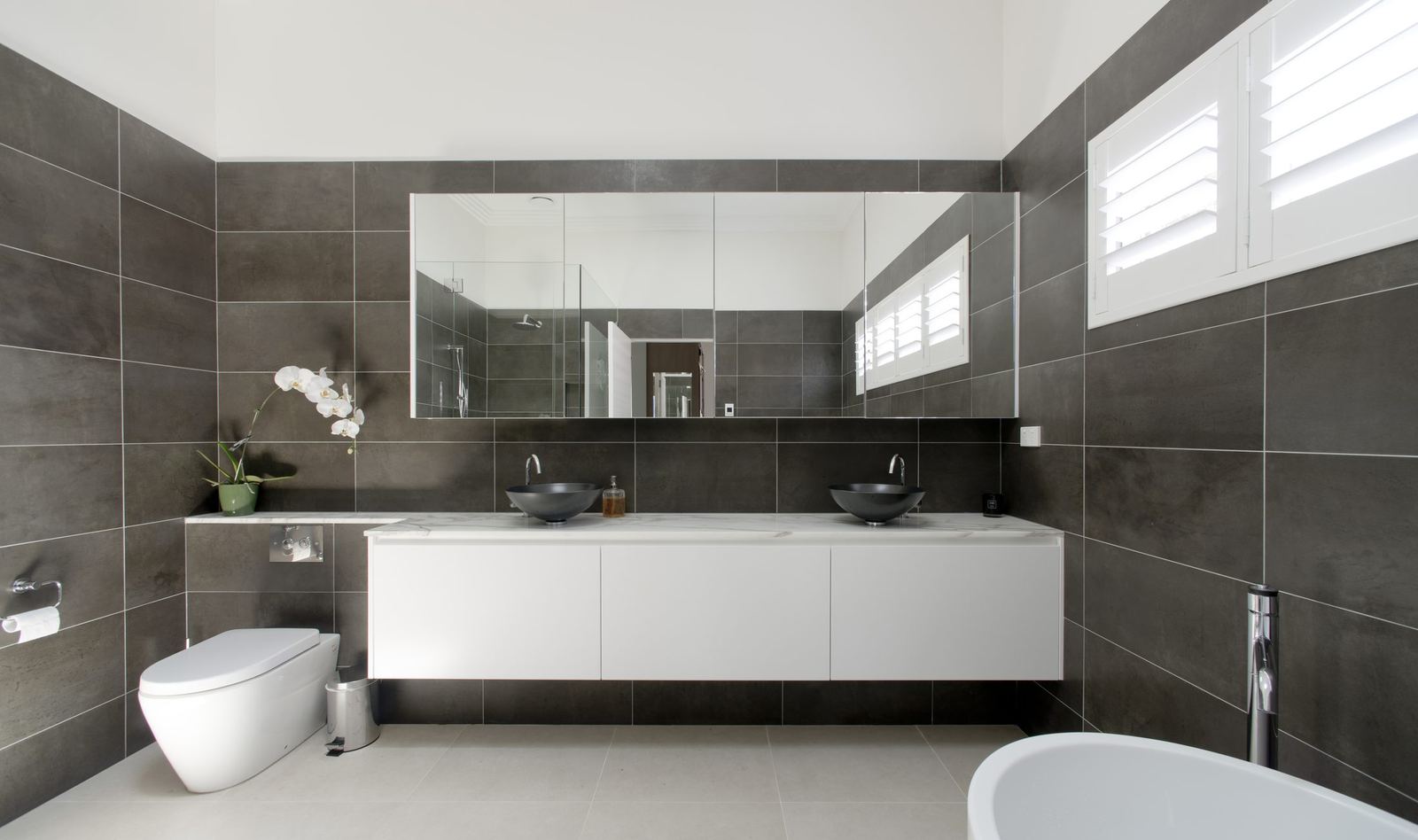 Balgowlah — bathroom with charcoal tiles, floating double vanity and freestanding bath, built by HP Constructions with Scope Architects