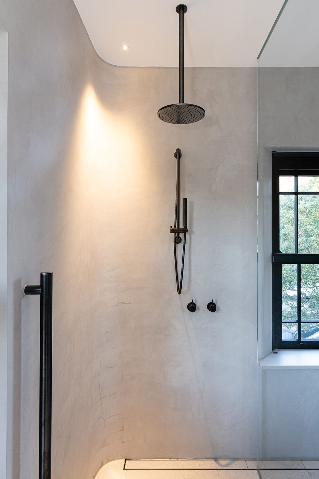 Bellevue Hill — microcement bathroom with black rain shower head and framed window, built by HP Constructions with Foster & Associates