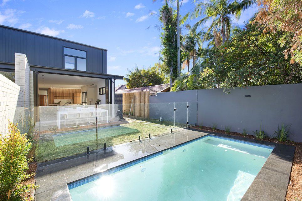 Bondi — backyard swimming pool with glass fencing behind the duplex, built by HP Constructions with Arkhaus