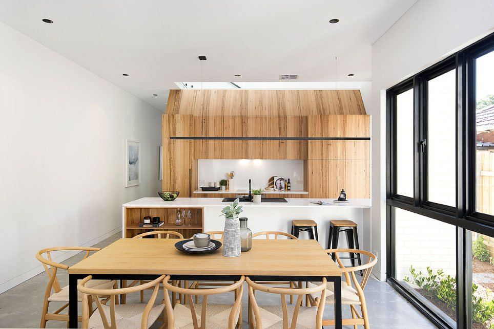 Bondi — open kitchen with timber joinery and dining table with wishbone chairs, built by HP Constructions with Arkhaus