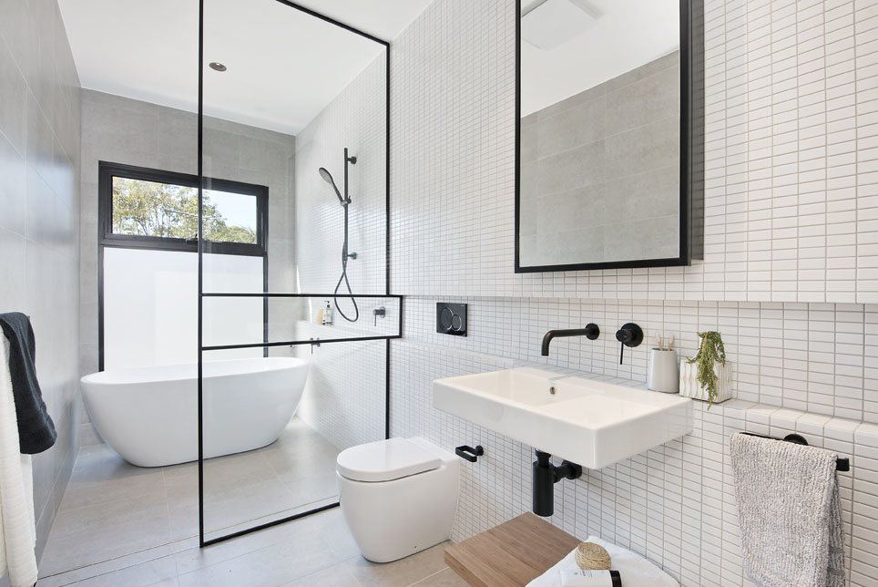 Bondi — bathroom with freestanding tub, walk-in shower and white tiling, built by HP Constructions with Arkhaus