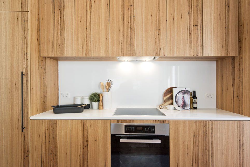 Bondi — timber kitchen cabinetry with stone benchtop, induction cooktop and oven, built by HP Constructions with Arkhaus