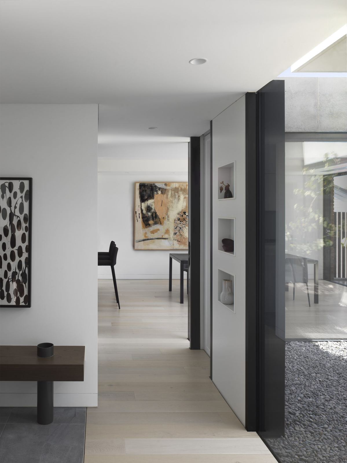 Castle Cove — gallery corridor hung with artwork opening to living space, built by HP Constructions with Dieppe Design