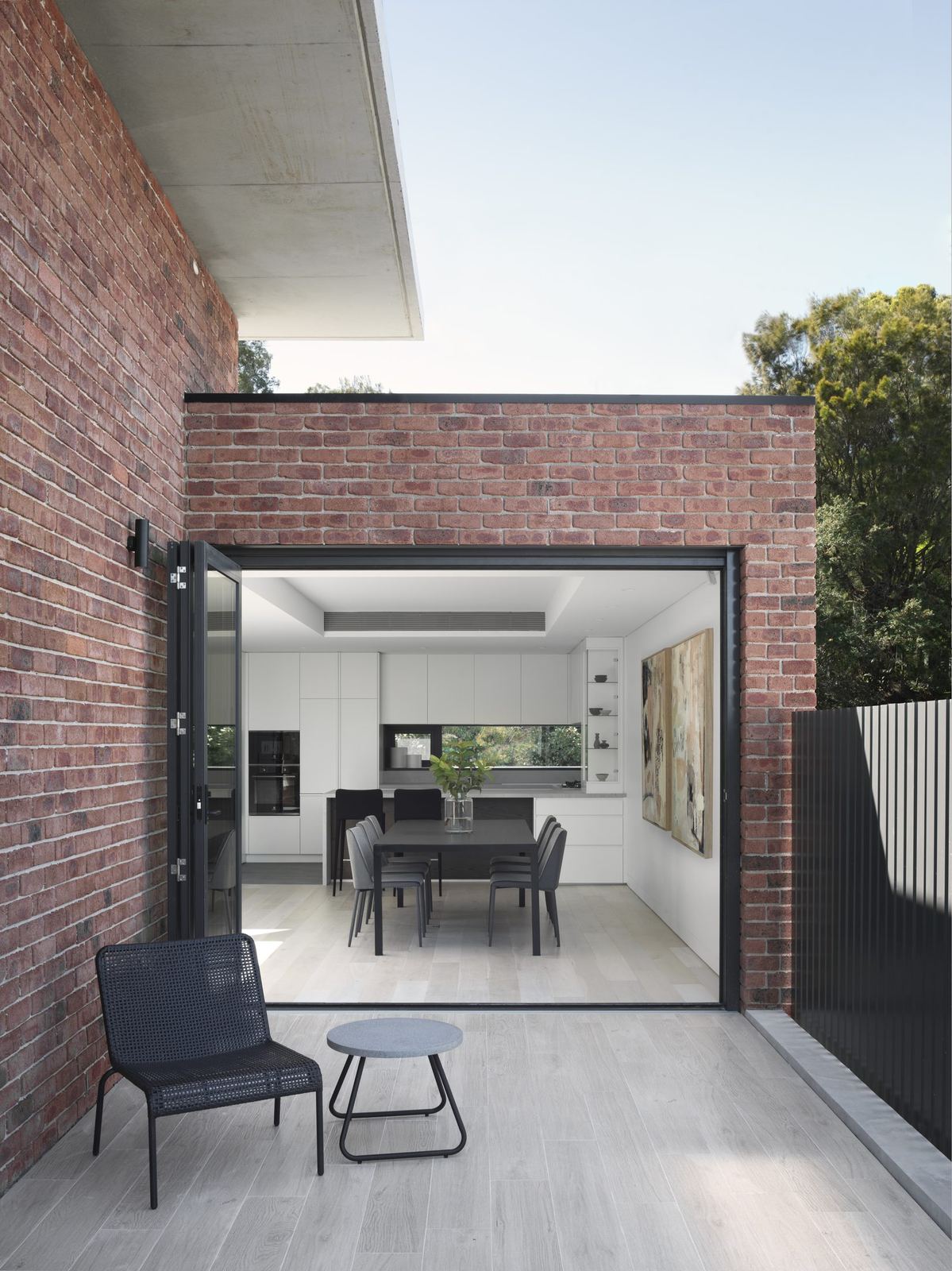 Castle Cove — brick wall with sliding door open to dining and terrace, built by HP Constructions with Dieppe Design