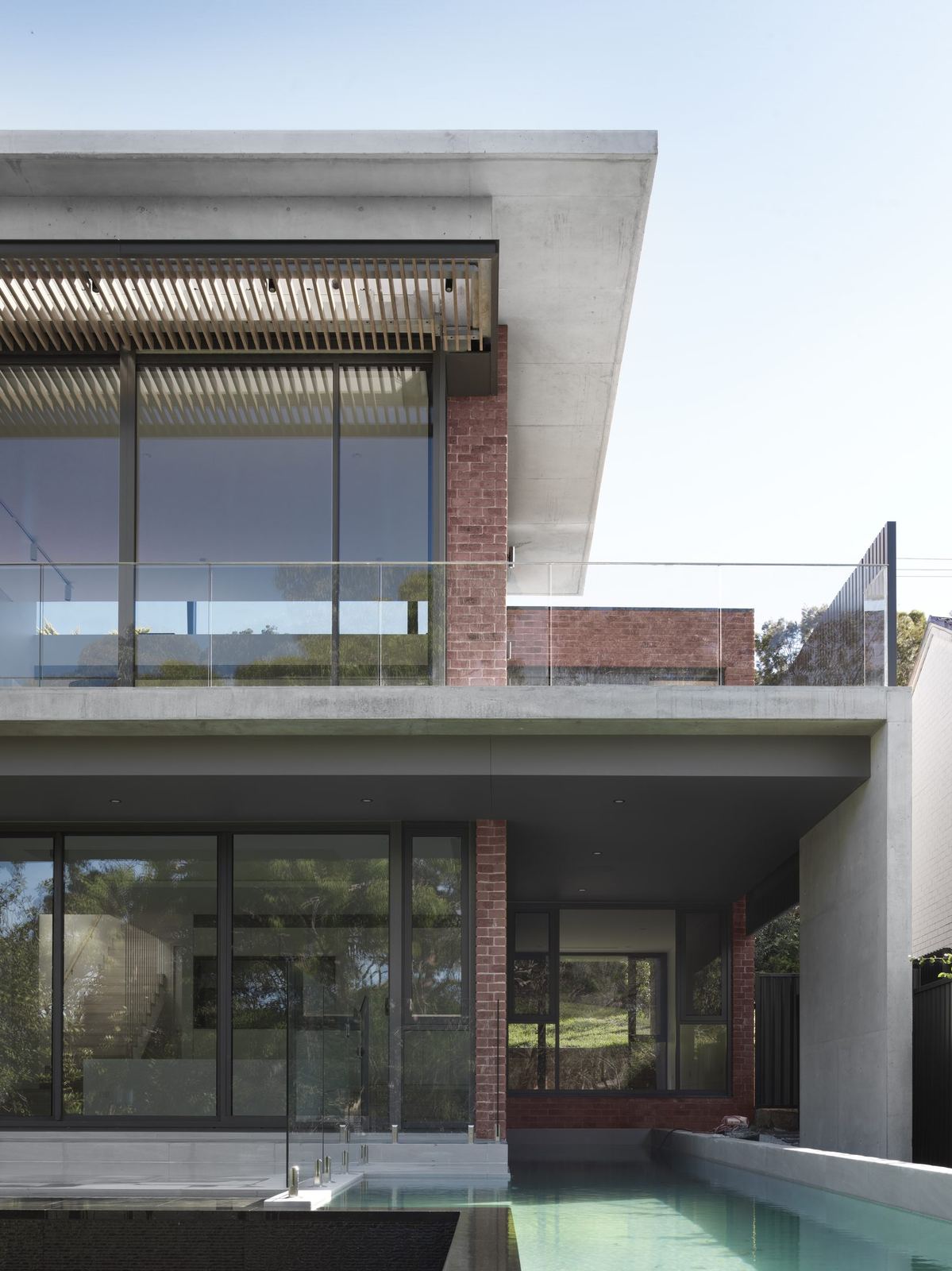 Castle Cove — brick and glass exterior with swimming pool below, built by HP Constructions with Dieppe Design