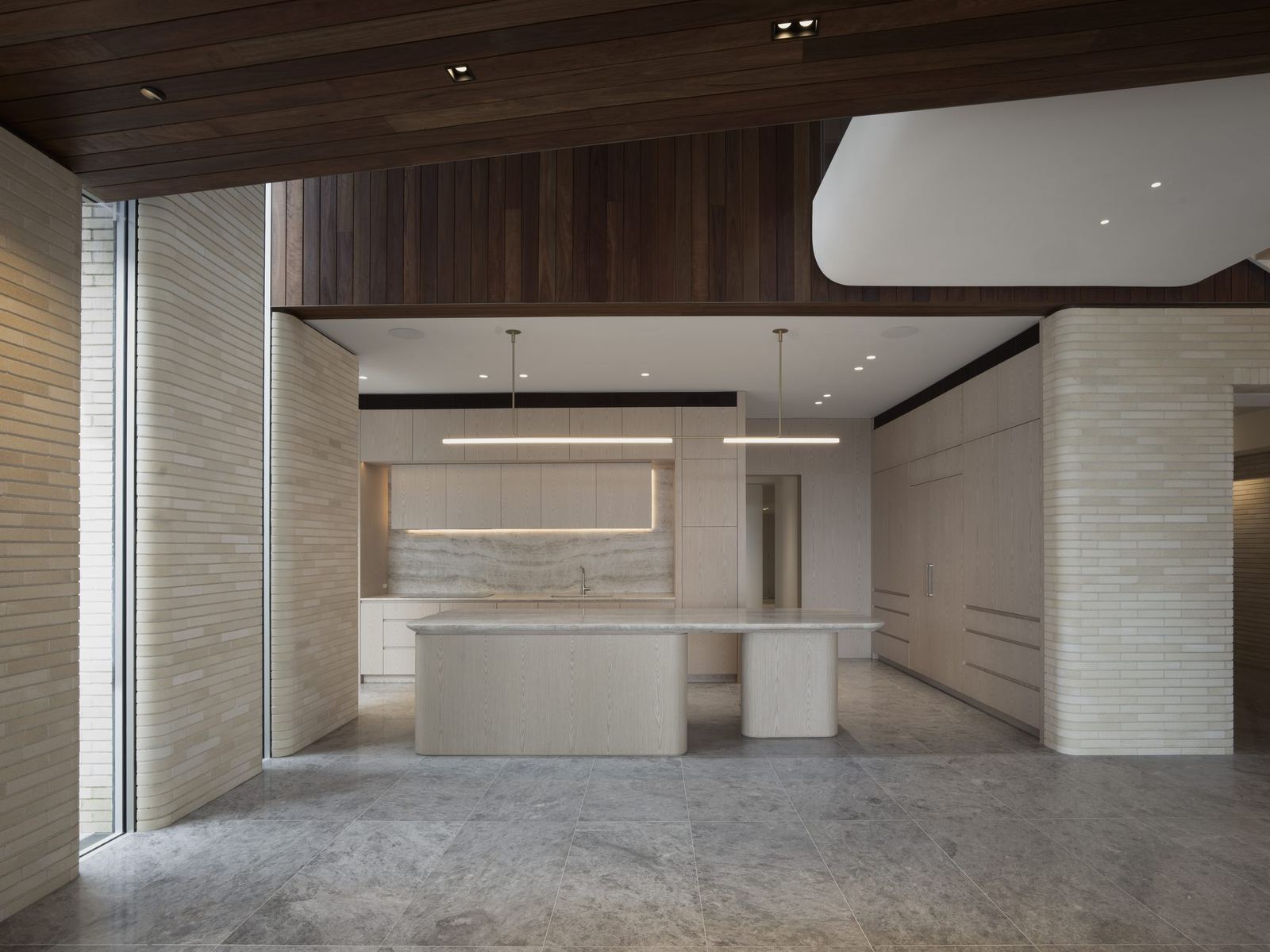 Castlecrag — kitchen with stone island, travertine walls and timber-lined ceiling, built by HP Constructions with FJC Studio