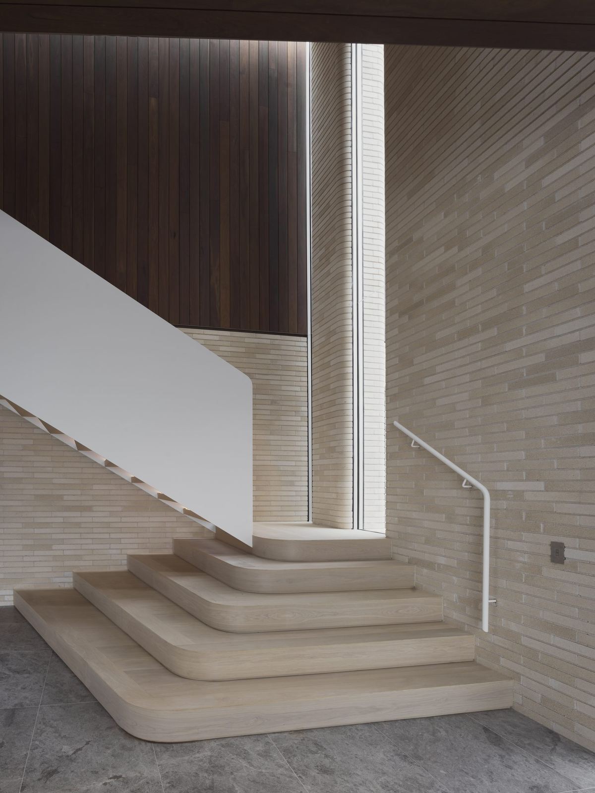 Castlecrag — curved travertine staircase detail against timber-clad wall, built by HP Constructions with FJC Studio