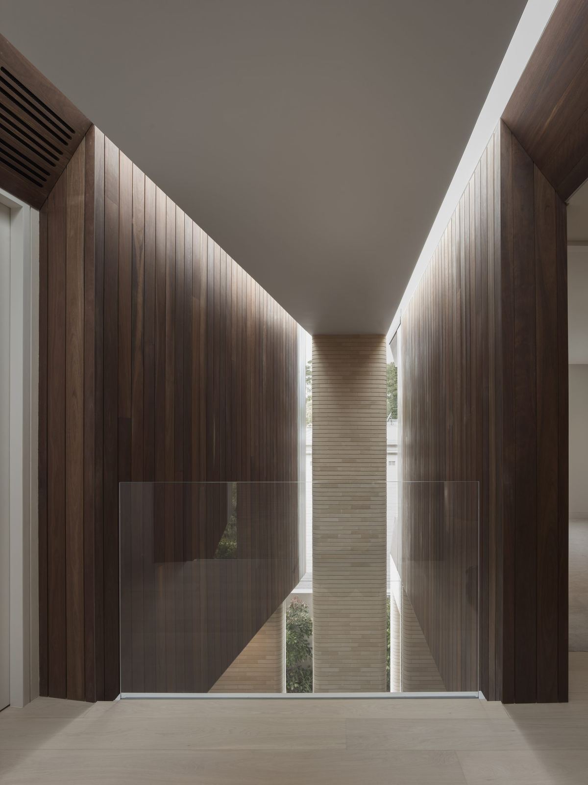 Castlecrag — corridor lined with timber walls and stone flooring, built by HP Constructions with FJC Studio