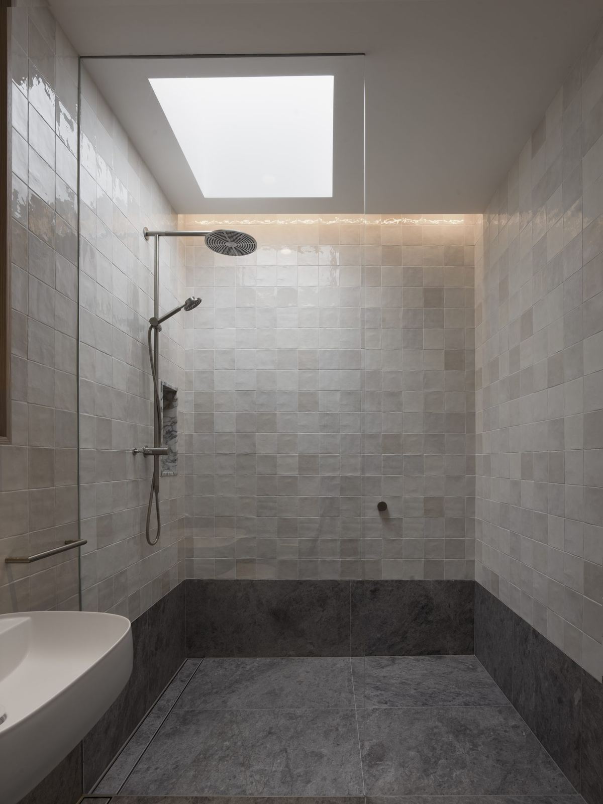 Castlecrag — stone-tiled shower room with skylight and built-in bench, built by HP Constructions with FJC Studio