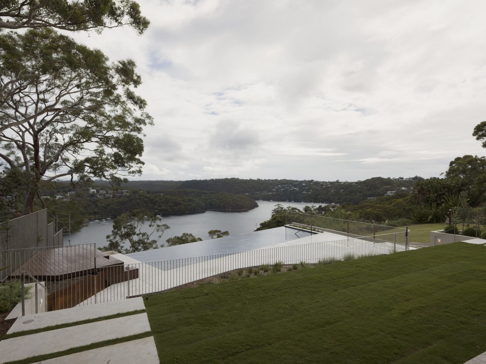 Castlecrag — terraced landscaped garden overlooking bushland and water inlet, built by HP Constructions with FJC Studio