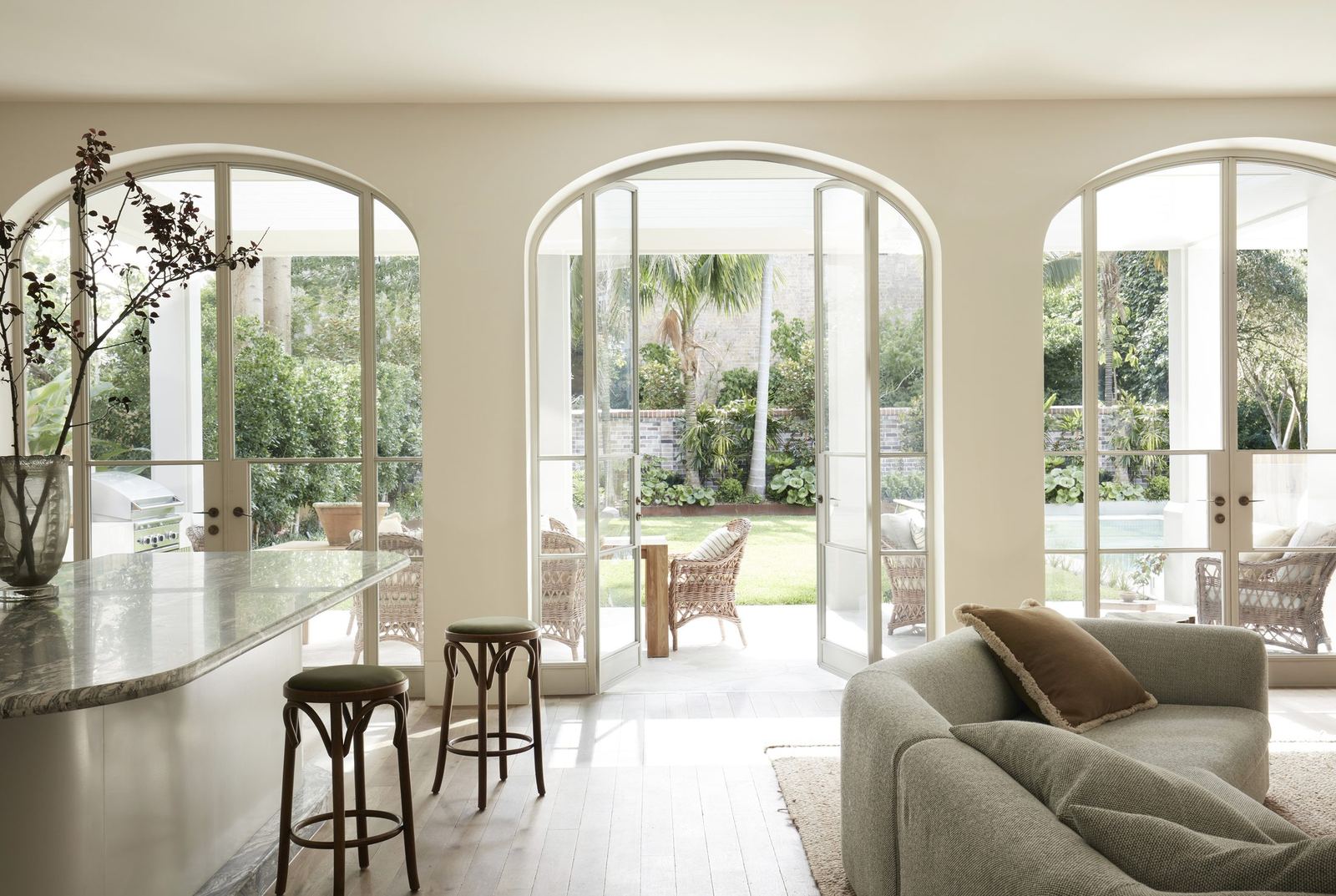 Darling Point — living room with tall arched glass doors opening to garden, built by HP Constructions with Hancock Architects