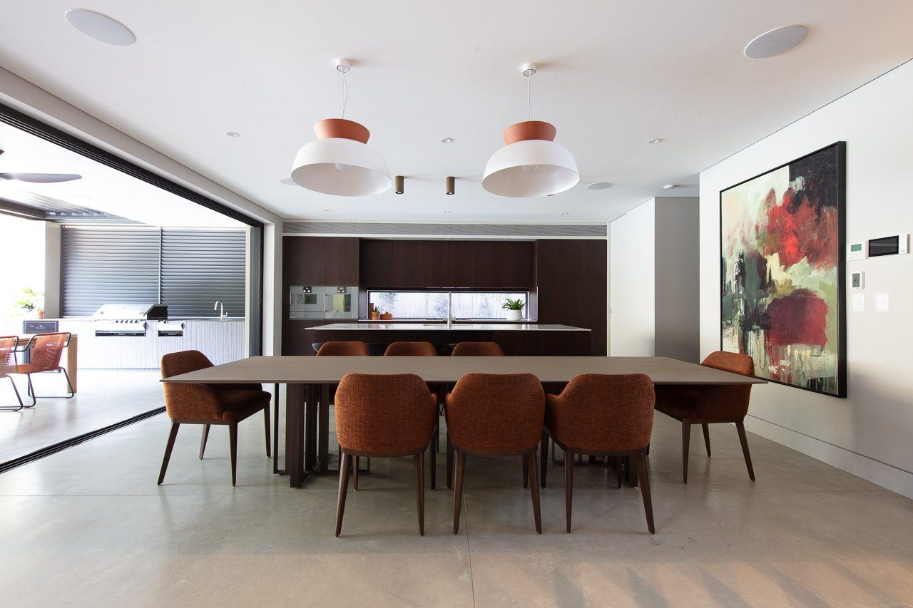 Hunters Hill — open-plan dining table with terracotta chairs and pendant lights, built by HP Constructions with Dale Design Group
