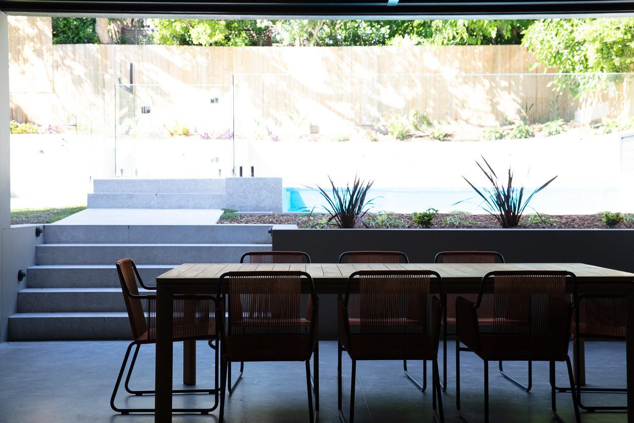 Hunters Hill — covered terrace dining table opening onto pool and stepped garden, built by HP Constructions with Dale Design Group
