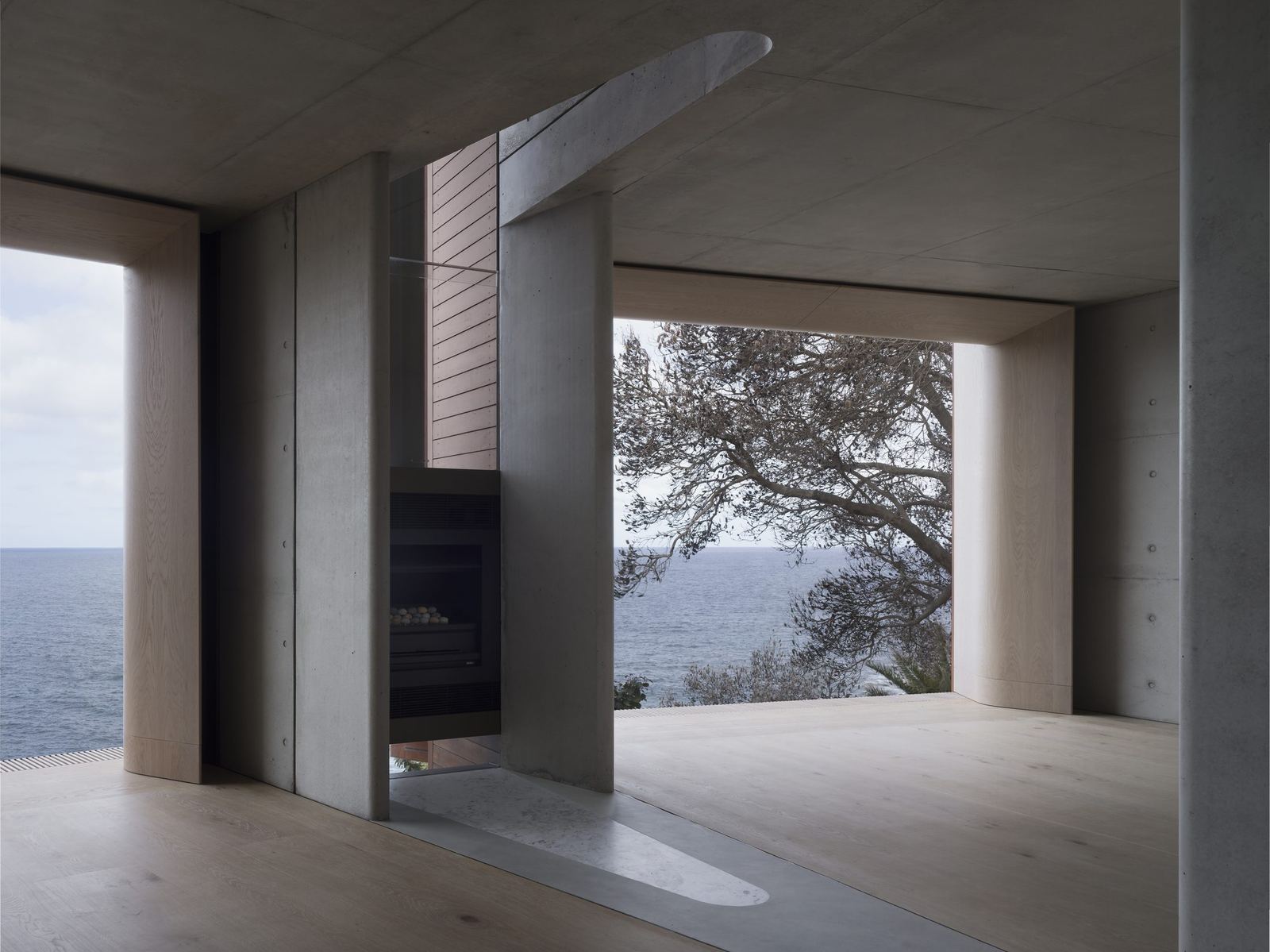 Lurline Bay — living room with fireplace and expansive coastal views, built by HP Constructions with FJC Studio
