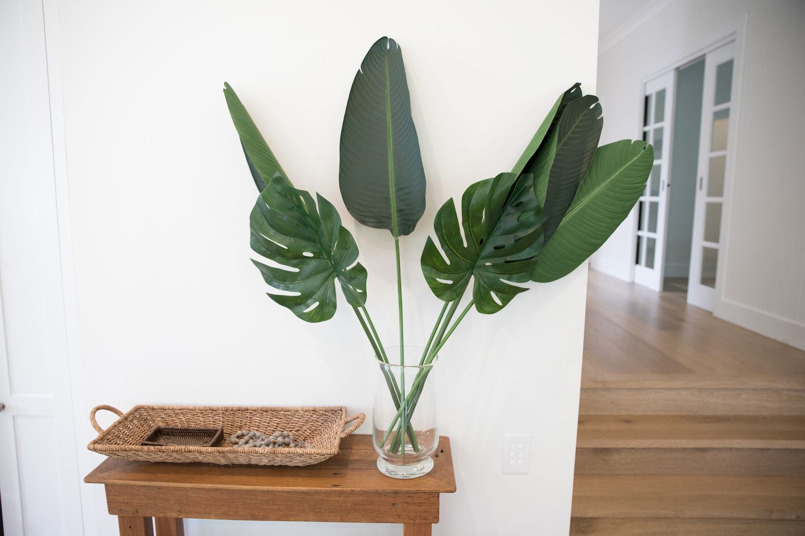 North Balgowlah — timber side table styled with vase of large green leaves, built by HP Constructions with J.D Evans & Co