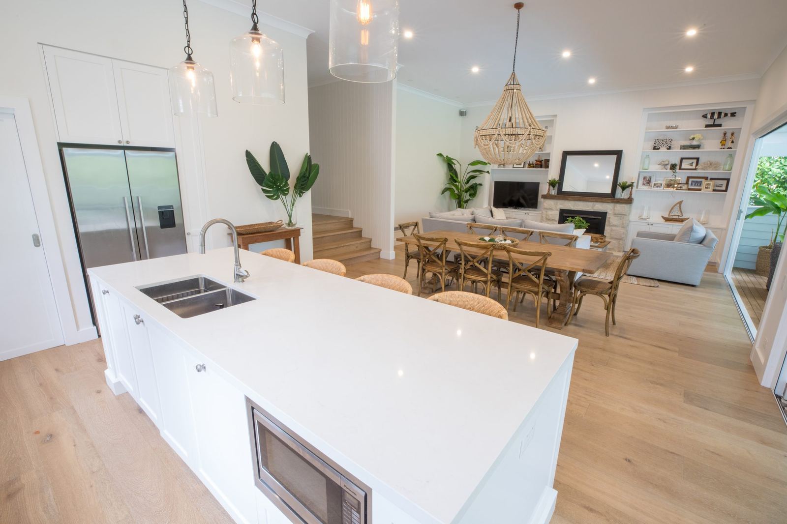 North Balgowlah — kitchen with white waterfall island, staircase and chandelier, built by HP Constructions with J.D Evans & Co