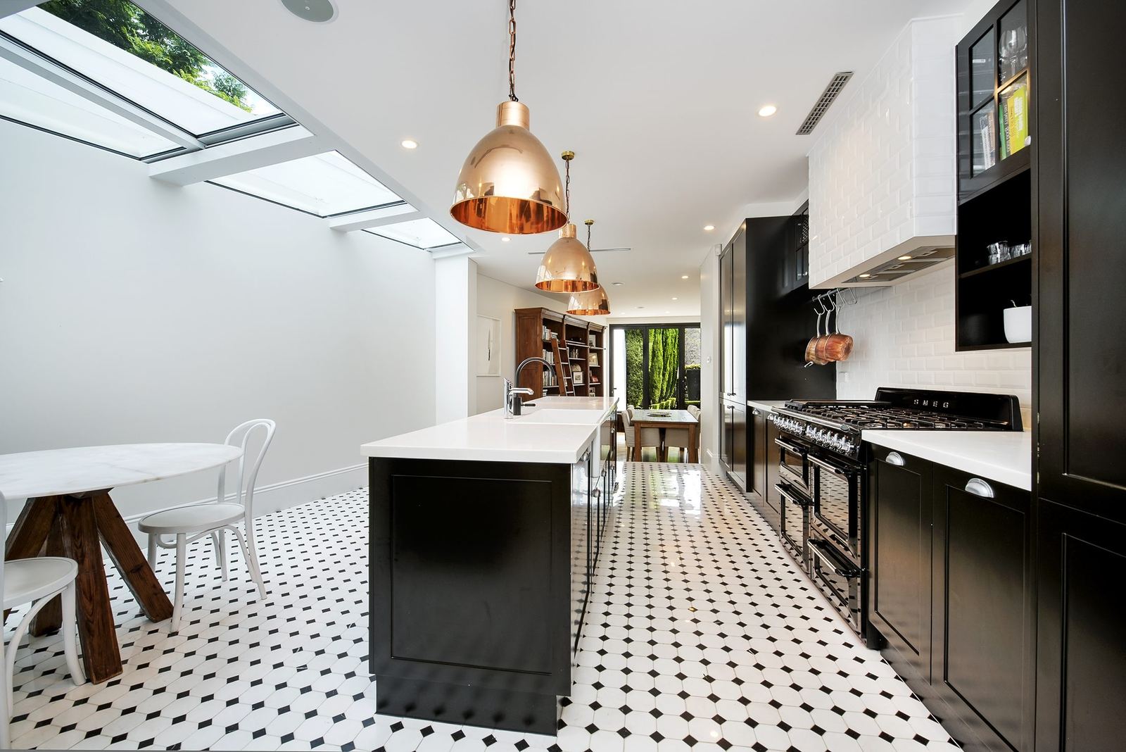 Paddington — kitchen with black joinery, white island, skylights and patterned floor tiles, built by HP Constructions with Gutnik Design Group