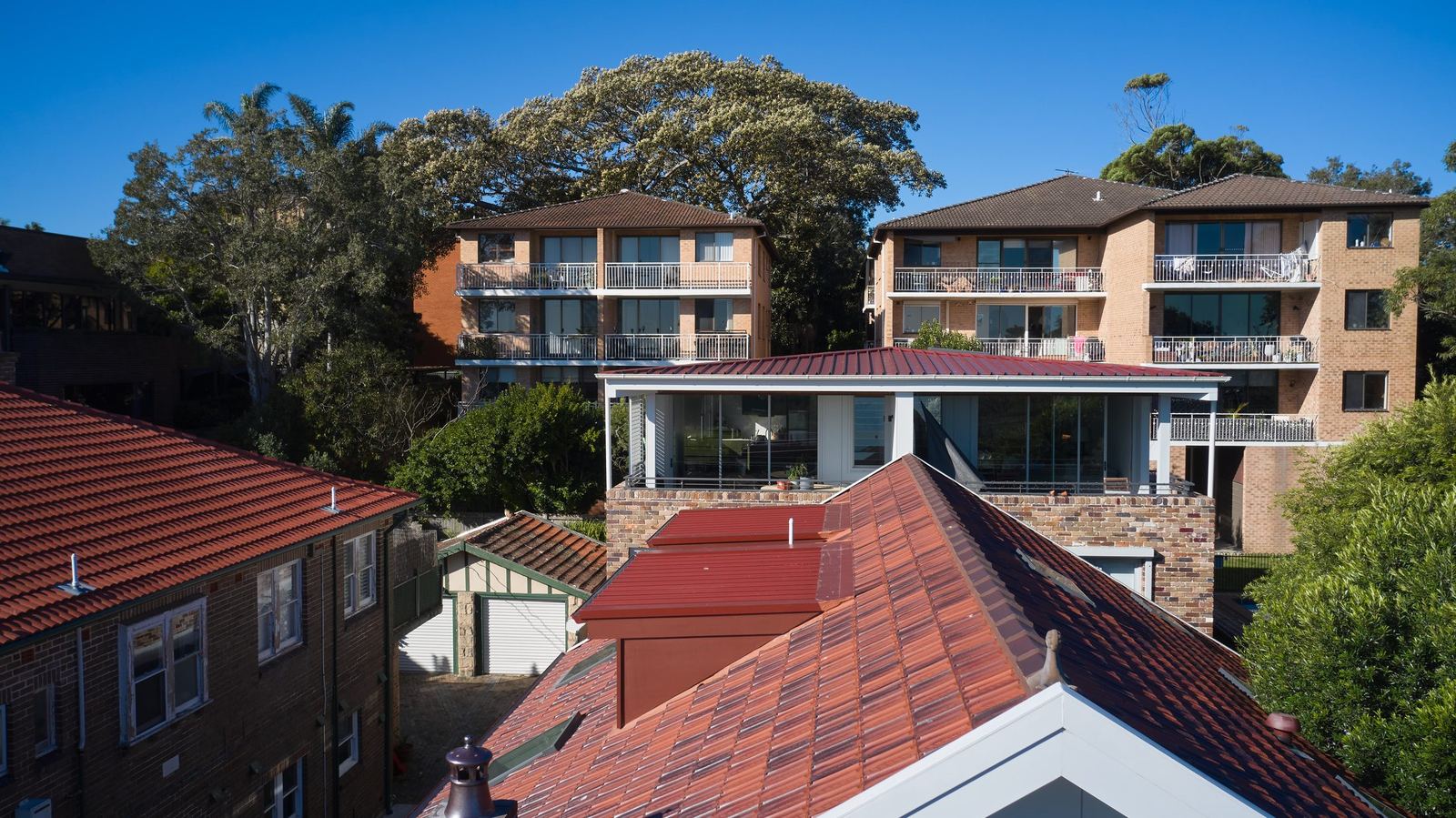 Queens Park Apartments — aerial exterior of apartment building among rooftops and trees, built by HP Constructions with Ignite Architects