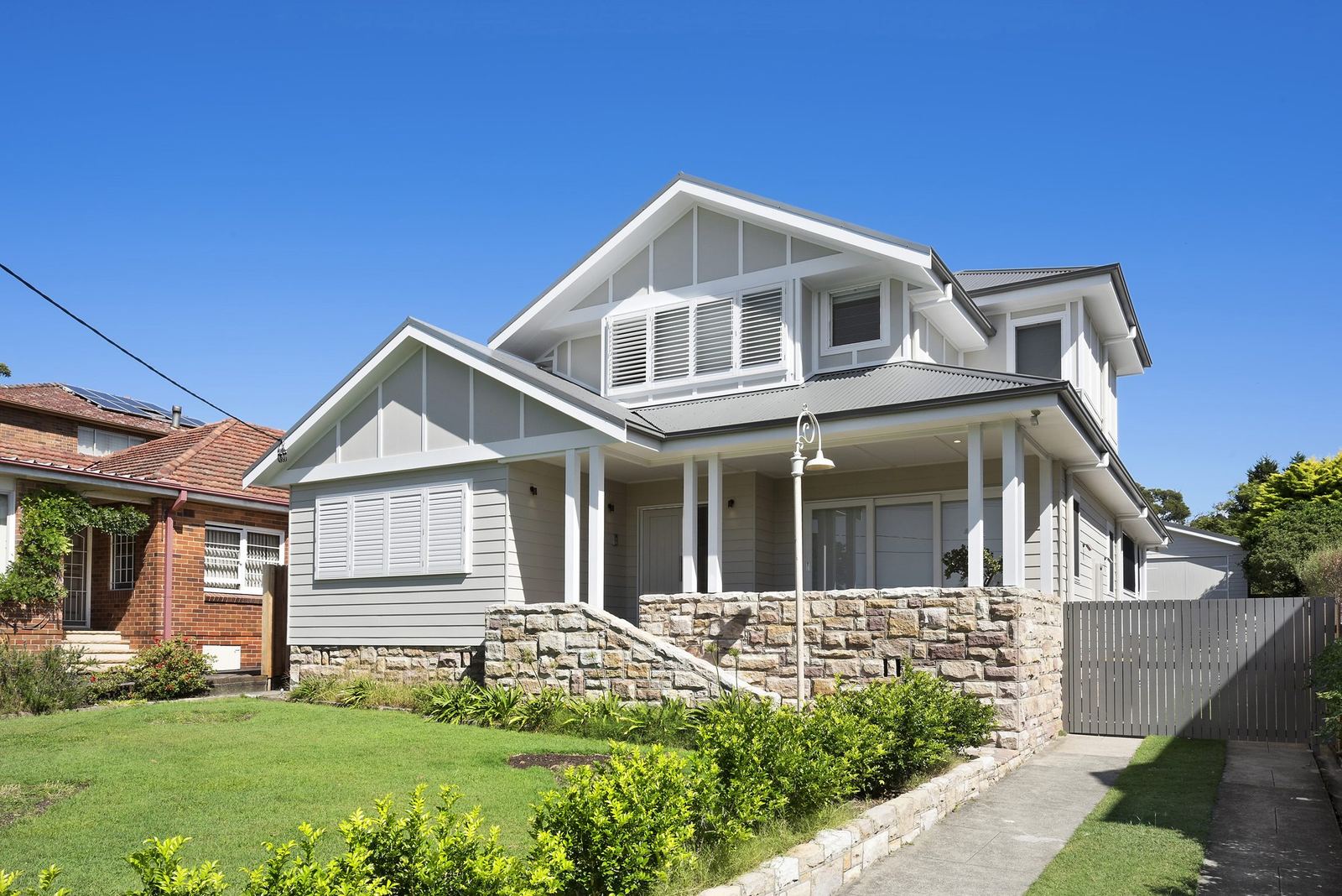 Seaforth — street facade of a two-storey home with gable roof and sandstone base, built by HP Constructions with Playoust Churcher