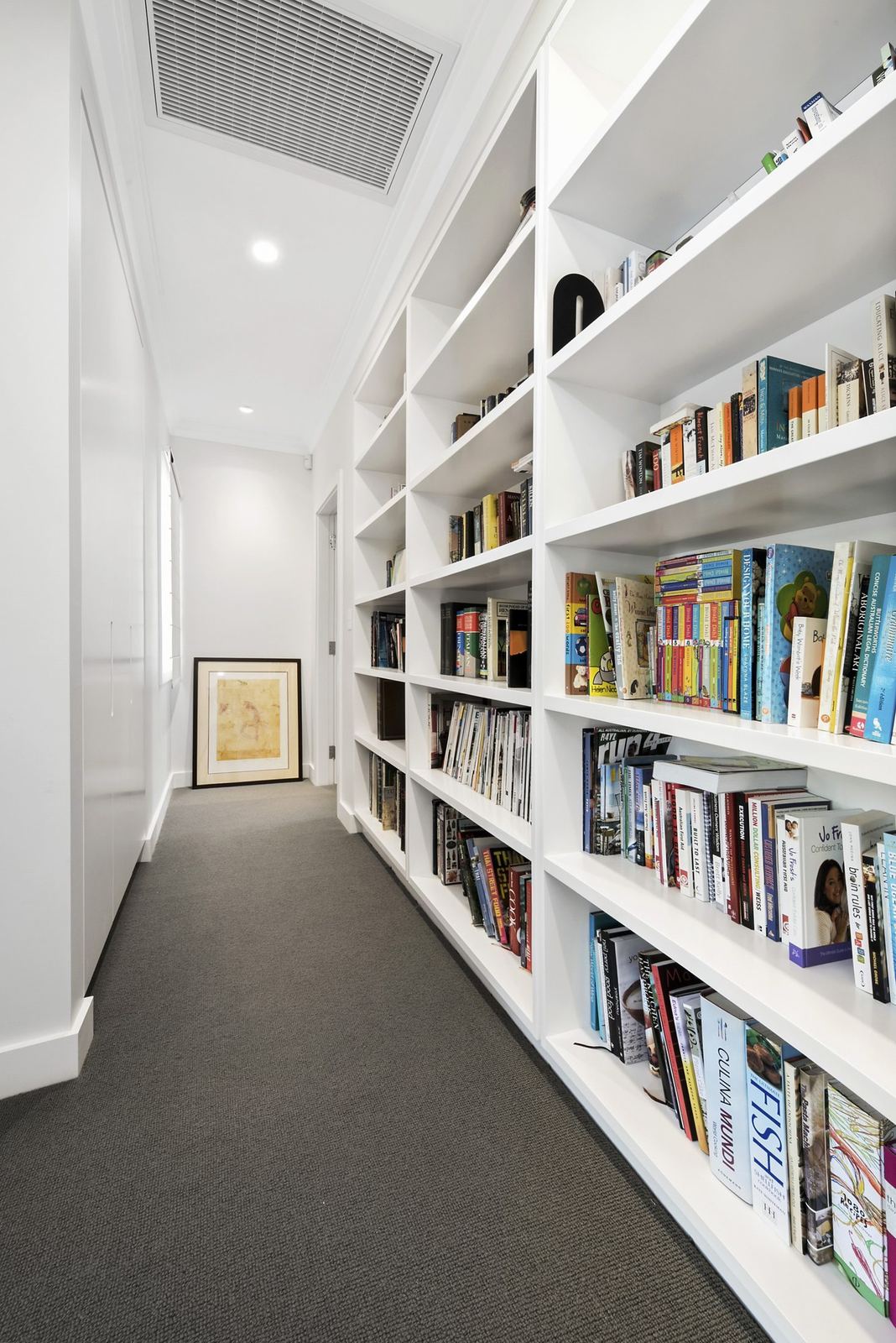 Seaforth — hallway lined with custom timber bookshelves and grey carpet, built by HP Constructions with Playoust Churcher