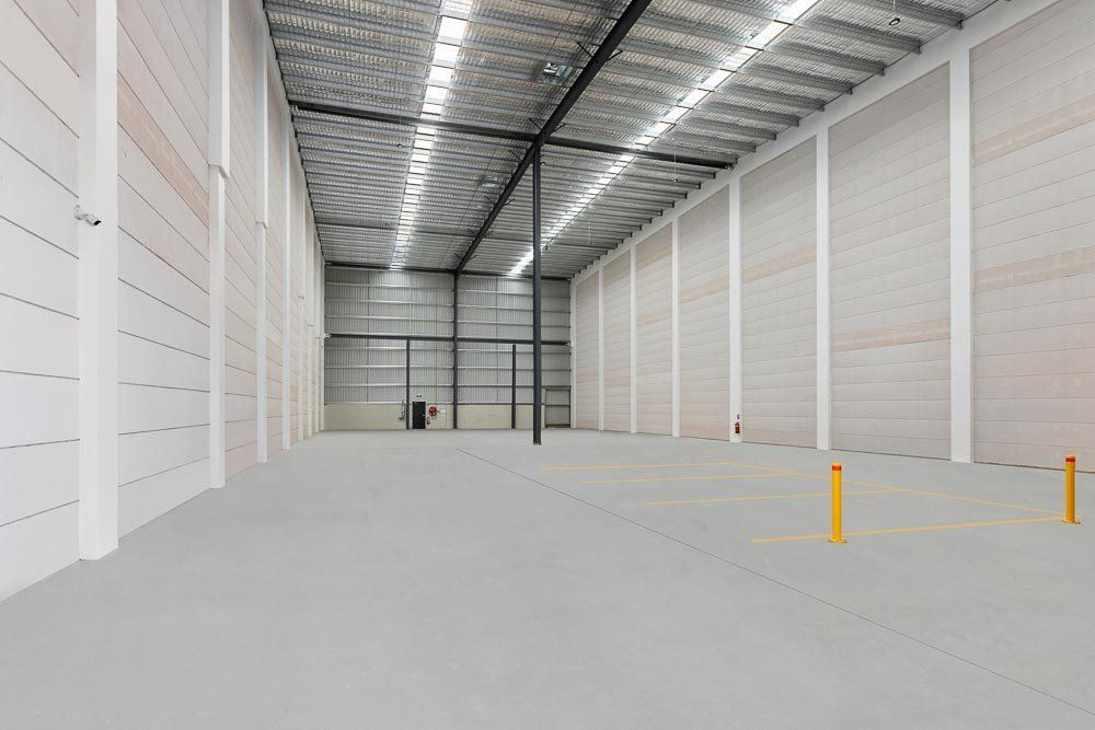 Thornleigh Warehouse — empty high-clearance warehouse interior with skylit roof and yellow bollards, built by HP Constructions