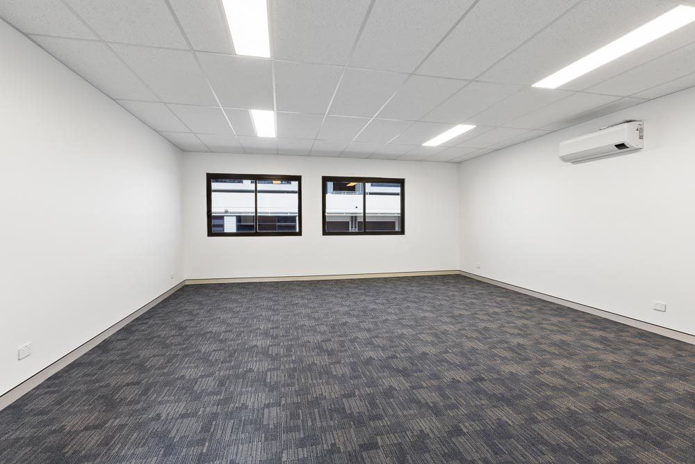 Thornleigh Warehouse — empty carpeted office suite with windows and ceiling tiles, built by HP Constructions